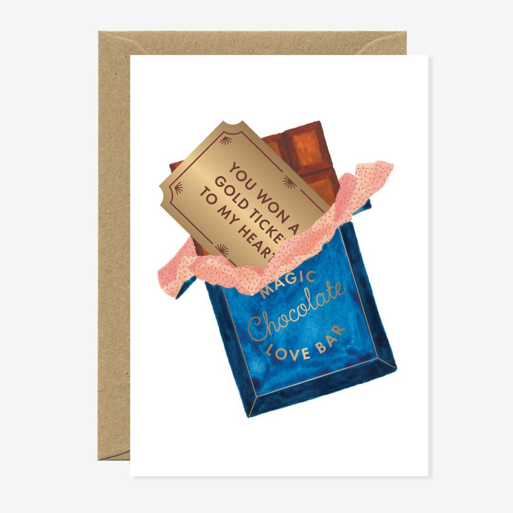 Schokoladentafel in blauer Verpackung mit Aufschrift 'Magic Chocolate Love Bar' und goldener Karte mit Text 'You won a gold ticket to my heart'