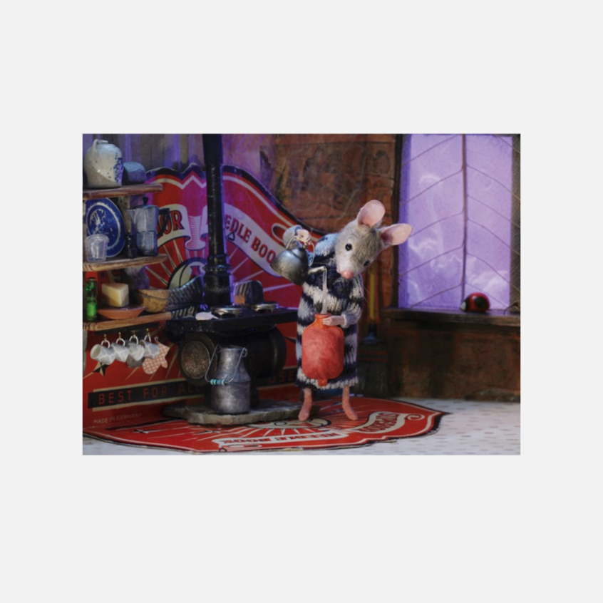 Eine Maus in einem gestreiften Kleid gießt Wasser in eine rote Wärmflasche