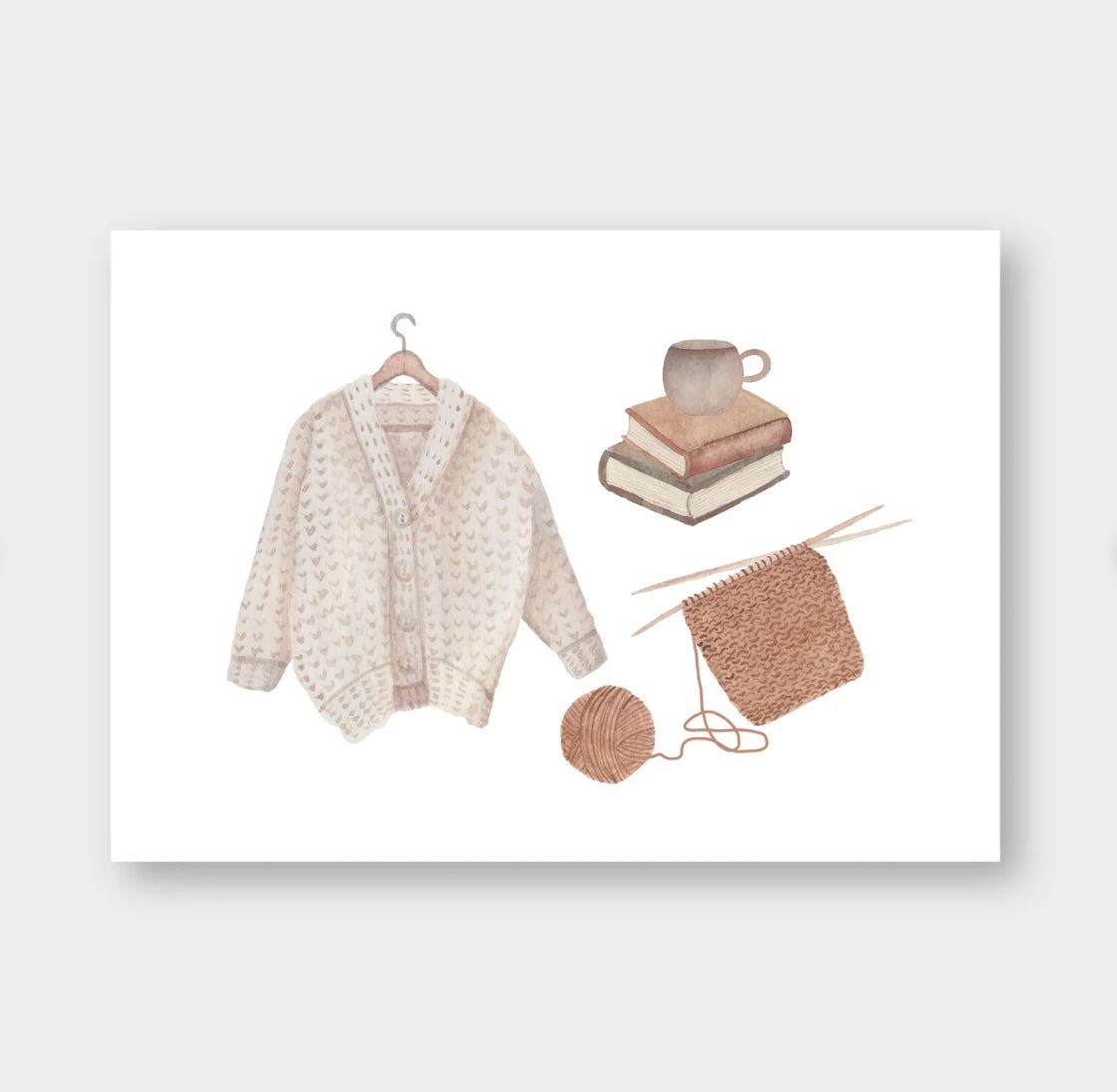 Beige Strickjacke auf Holzkleiderbügel, zwei Bücher mit grauer Tasse darauf, braunes Strickstück mit Stricknadeln und Wollknäuel.