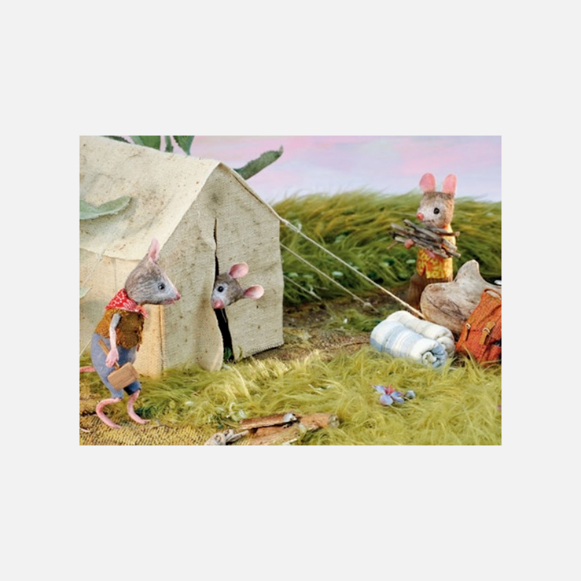 Drei Mäusefiguren in Kleidung beim Camping mit Zelt, Schlafsack, Rucksack und gesammeltem Holz auf Gras
