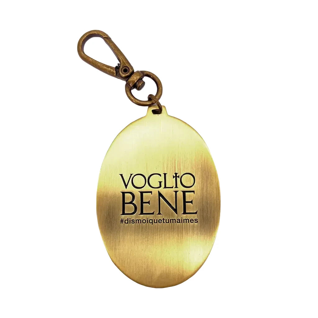 Ovaler goldfarbener Schlüsselanhänger mit der Gravur 'VOGLIO BENE' und dem Hashtag '#dismoiquetumaimes'
