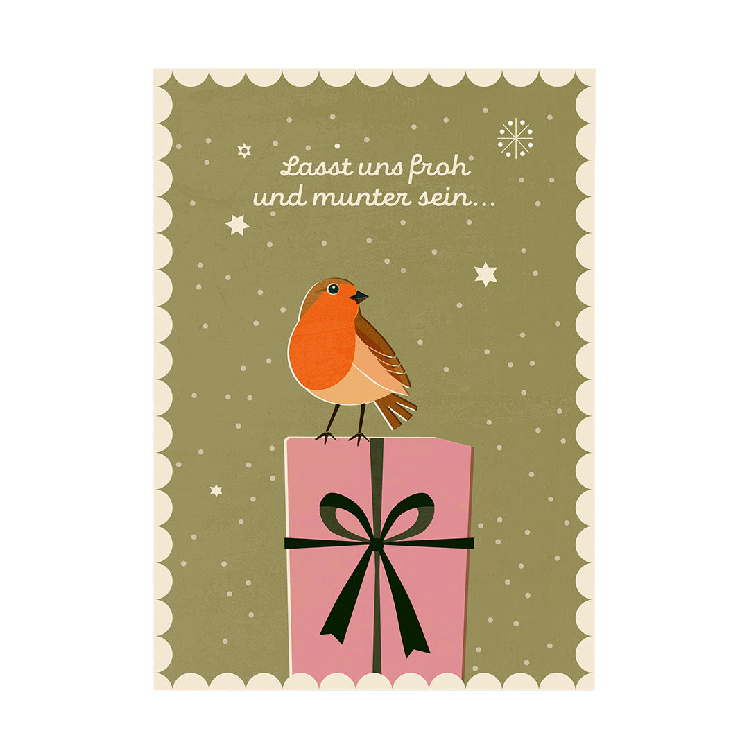 Eine illustrative Weihnachtskarte auf einem graugrünen Hintergrund mit vielen kleinen Schneeflocken und Sternen. Oben steht in geschwungener Schrift „Lasst uns froh und munter sein...“. In der Mitte sitzt ein Rotkehlchen auf einem großen, rosafarbenen Geschenk mit einer dunkelgrünen Schleife. Die Karte hat einen dekorativen cremefarbenen, gewellten Rand.