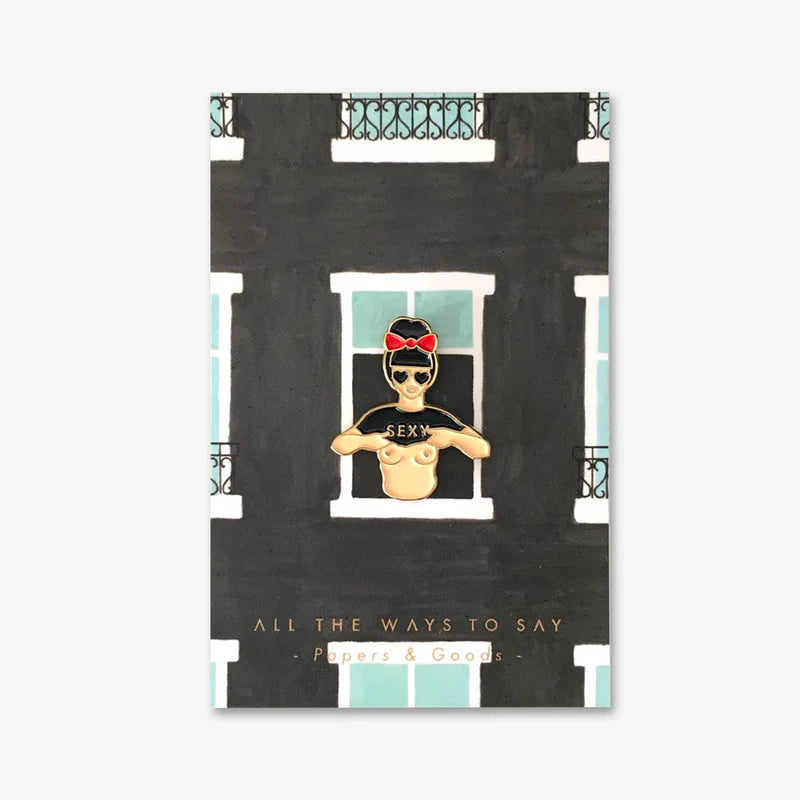 Illustration einer Person mit roter Schleife im Haar, die ein schwarzes Shirt mit der Aufschrift 'SEXY' trägt und sich an einem Fenster eines Gebäudes mit schwarzen Wänden und weißen Fensterrahmen lehnt.