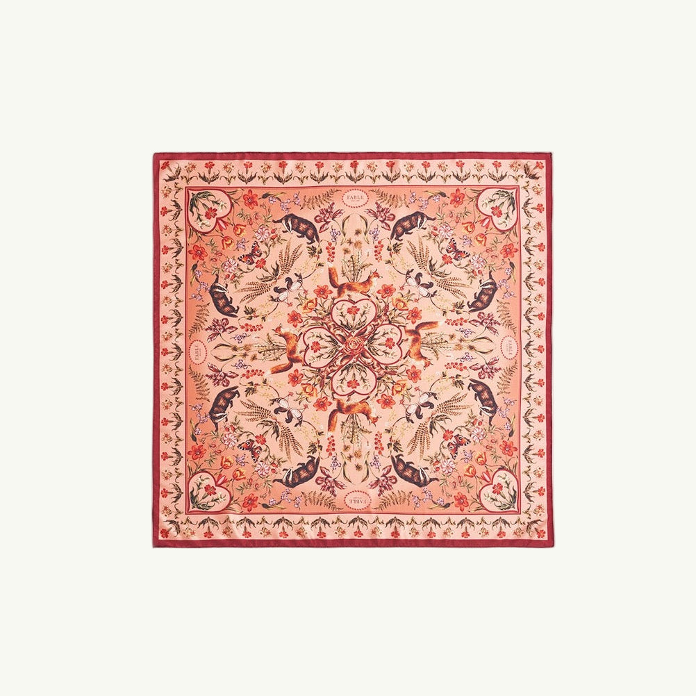 Quadratisches Tuch mit rotem Rand und floralem Muster in Rot, Blau und Beige, symmetrisch angeordnet.