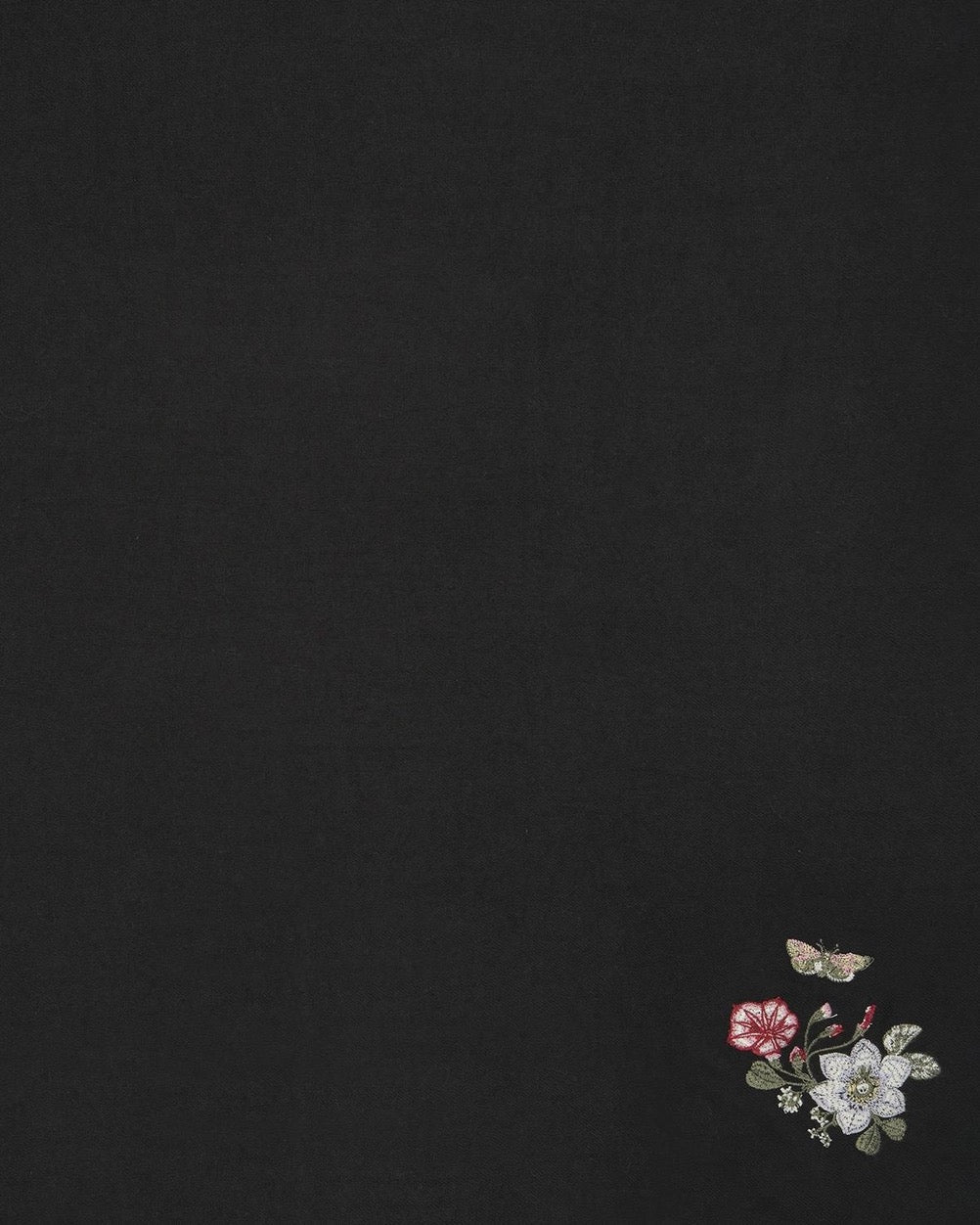 Schwarzer Schal mit kurzen Fransen und besticktem Blumenmuster in Weiß, Rot und Grün.