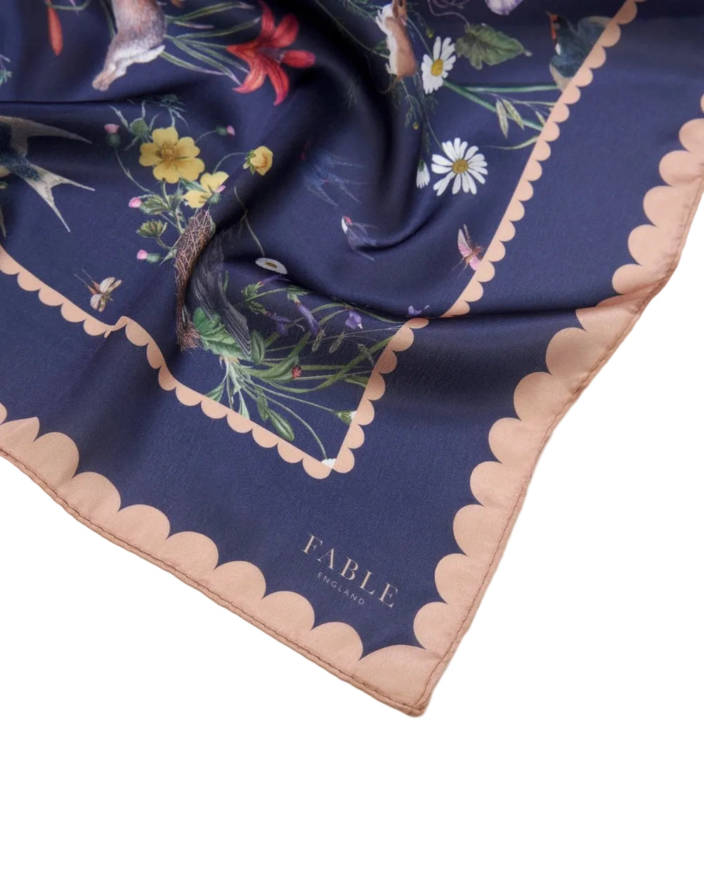 Quadratisches Tuch mit dunkelblauem Grund, floralem Muster in verschiedenen Farben und rosa gewelltem Rand.