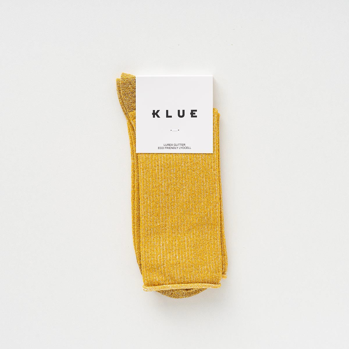 KLUE Lurex-Glitzersocken aus nachhaltigem Bamboo-Lyocell in Gelb mit weißer Papier-Banderole auf weißem Hintergrund.