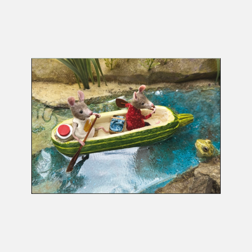 Zwei kleine Filzmäuse in einem ausgehöhlten Zucchini-Boot auf blauem Wasser, beobachtet von einem Frosch.