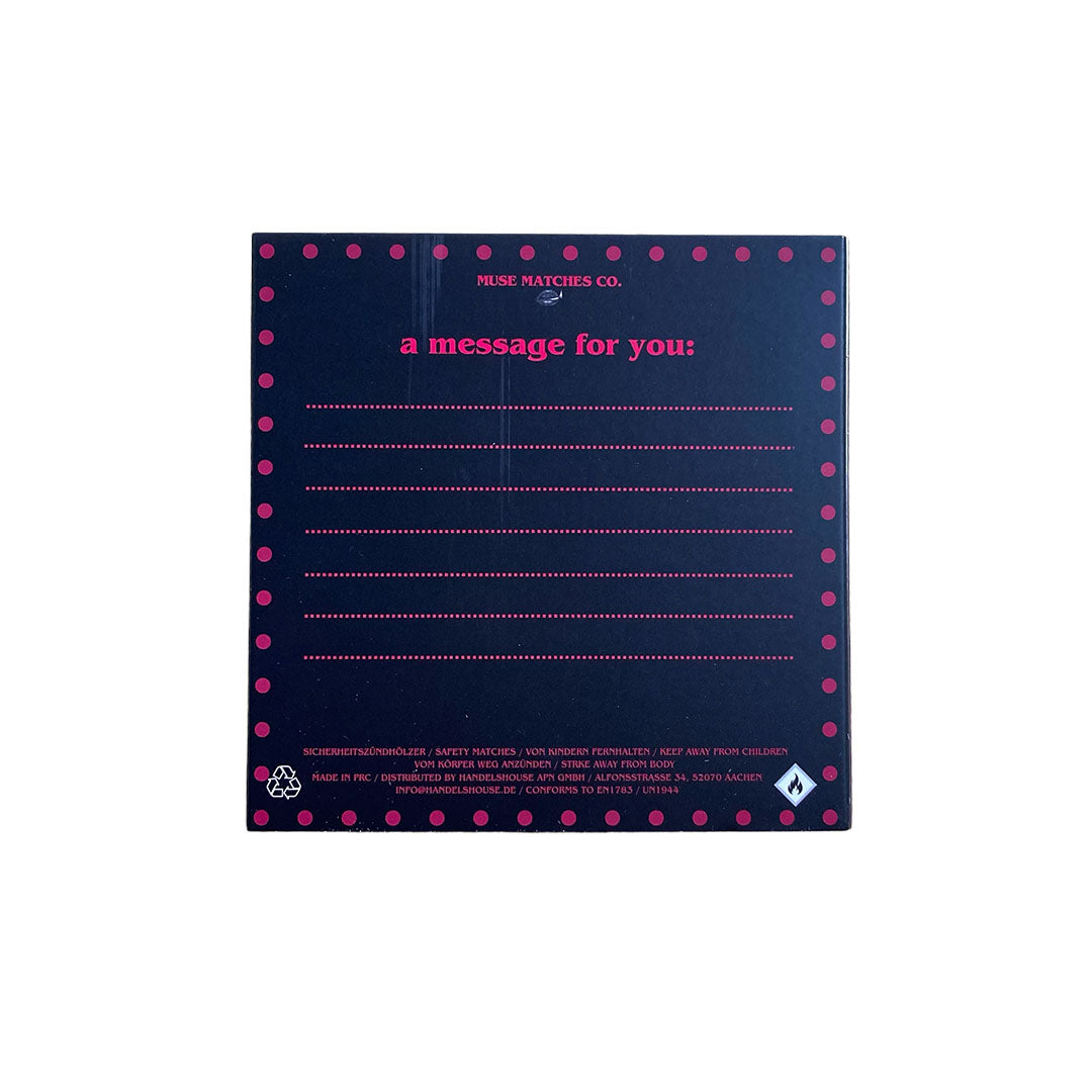 Dunkle, pink gepunktete Rückseite der Fucking Happy Streichholzschachtel mit Linien für persönliche Nachrichten und der Aufschrift a message for you.