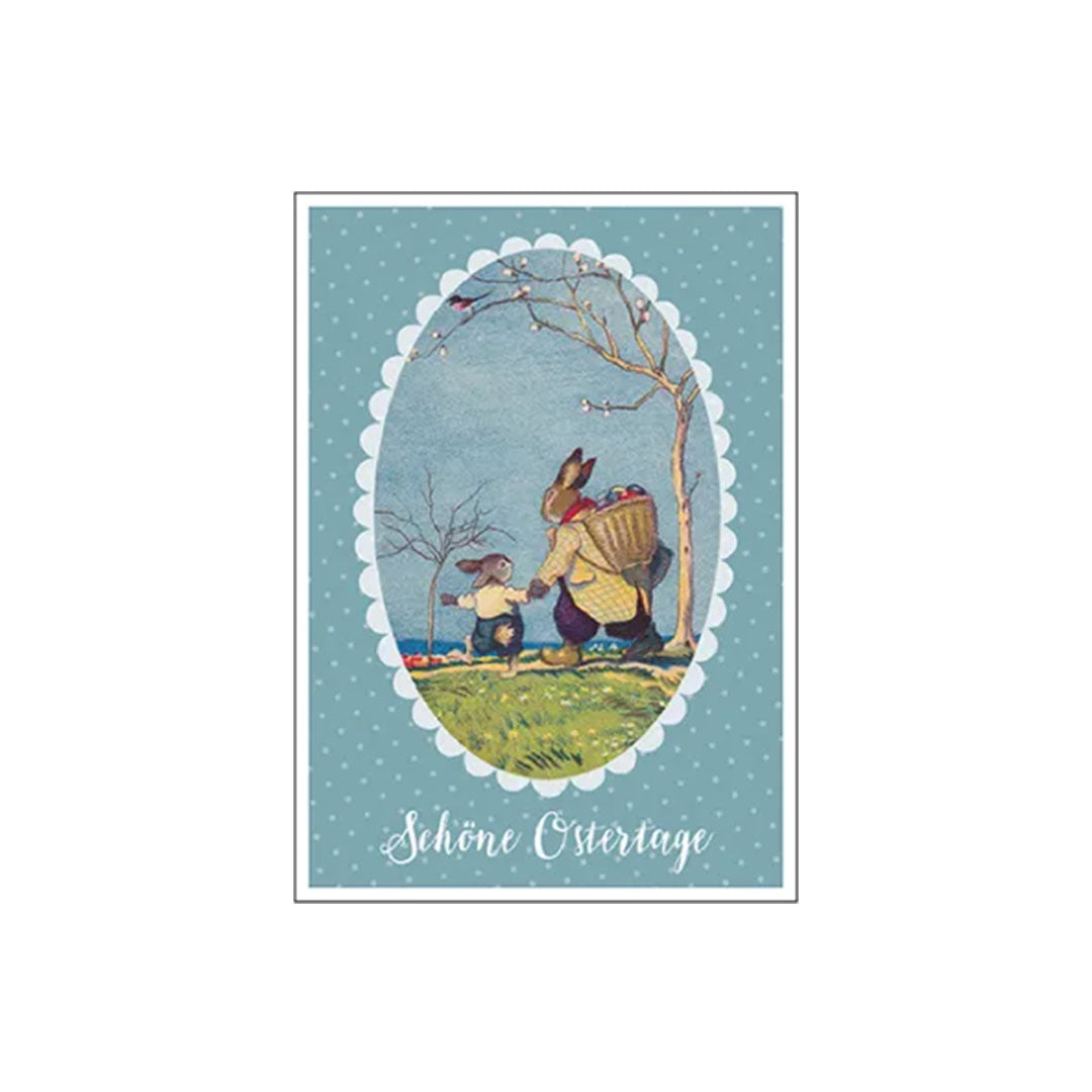 Eine nostalgische Osterkarte im Vintage-Stil. Ein großer und ein kleiner Hase wandern an einer Küste entlang; der große Hase trägt einen Korb voller bunter Ostereier auf dem Rücken. Text unten: „Schöne Ostertage