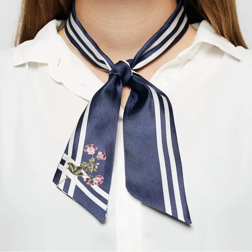 Modisches Accessoire: Blau gestreifter Twilly-Schal eng am Hals einer Frau geknotet.