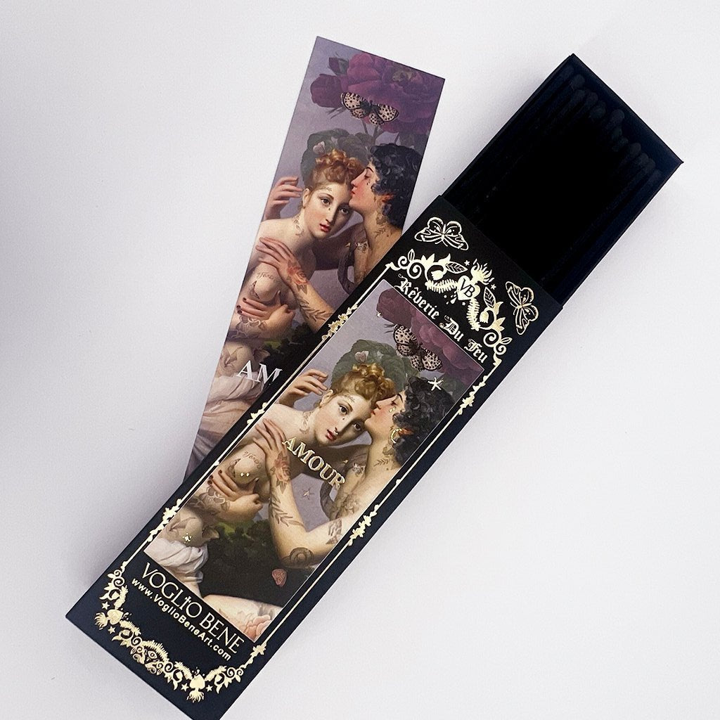 Schwarze Streichholzschachtel mit kunstvollem Etikett 'Vierge Du Feu' und floralen Verzierungen, daneben eine passende Karte mit klassischer Malerei