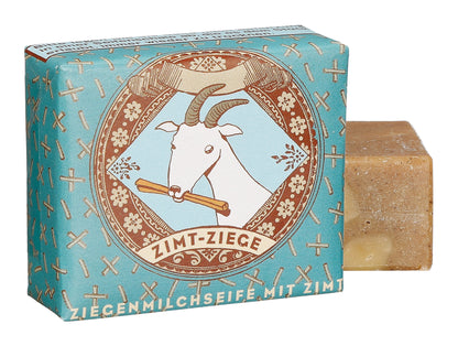 Verpackte Zimt-Ziege Ziegenmilchseife von 1000 und 1 Seife in blauem Papier mit Ziegen-Illustration und Seifenstück.
