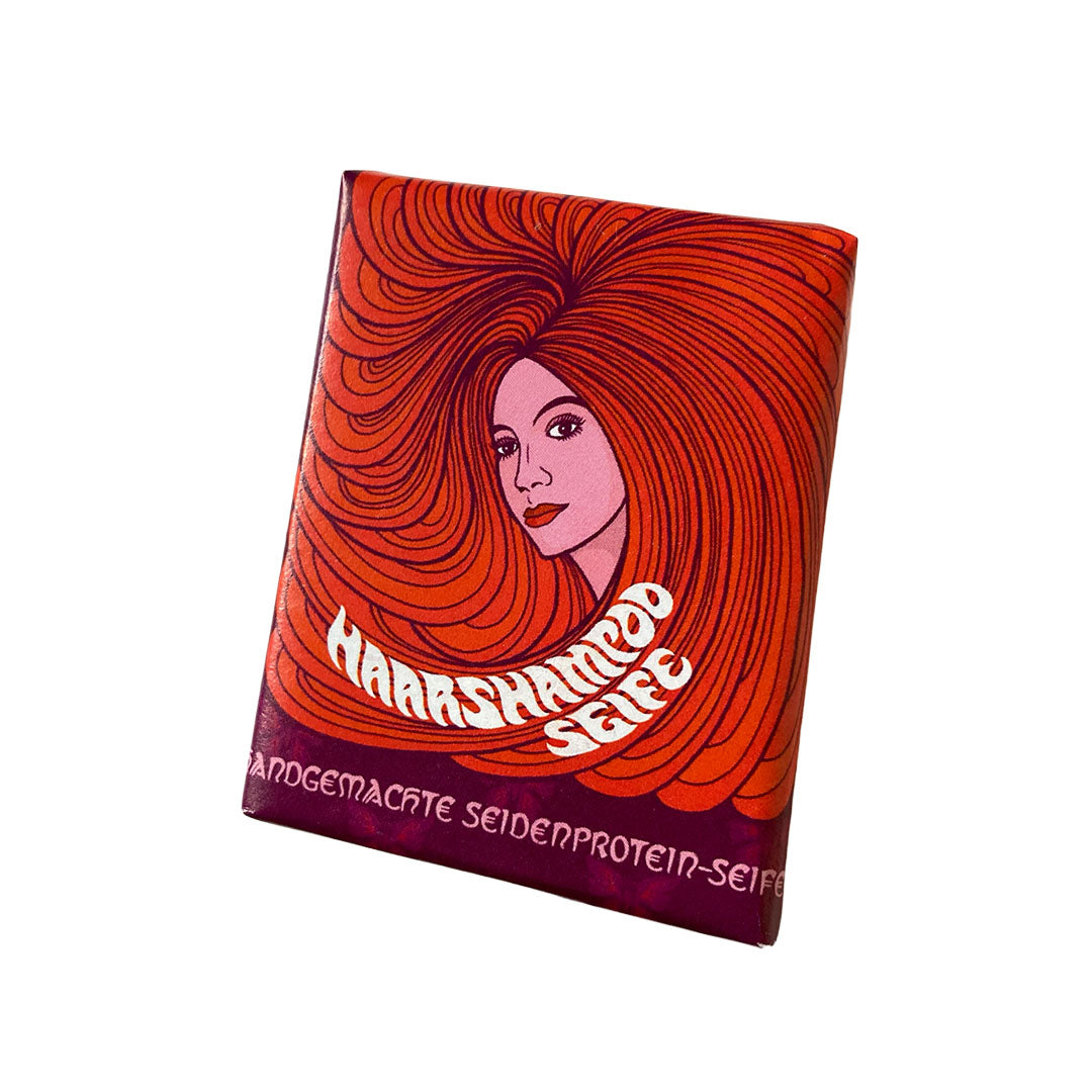 • 
Haarshampoo Seife von 1000 und 1 Seife in rot-oranger Verpackung mit Illustration einer Frau mit langen Haaren
