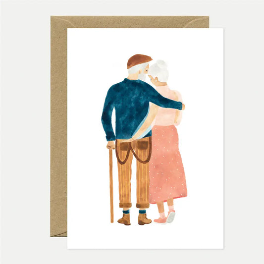 Illustration eines Paares, das sich umarmt, der Mann trägt eine blaue Jacke und braune Hose, die Frau einen rosa Rock mit Punkten