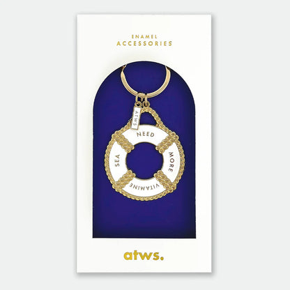 Schlüsselanhänger in Form eines Rettungsrings mit den Worten 'NEED MORE VITAMINE SEA' und Anhänger mit 'ATWS', verpackt auf weißer Karte mit 'ENAMEL ACCESSORIES' und 'atws.'