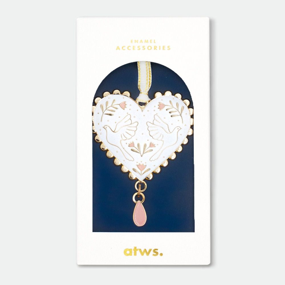 Herzförmiger Anhänger mit goldfarbenem Rand, weißem Hintergrund, zwei Tauben und floralen Mustern, rosa Tropfenanhänger, in Verpackung mit Aufschrift 'ENAMEL ACCESSORIES' und 'atws.'