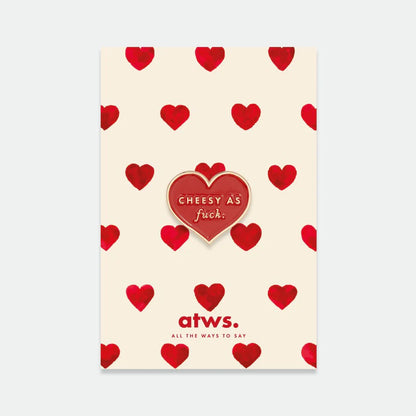 Rote Herz-Anstecknadel mit dem Text 'CHEESY AS fuck.' auf cremefarbenem Hintergrund mit roten Herzen, darunter Schriftzug 'atws. ALL THE WAYS TO SAY'