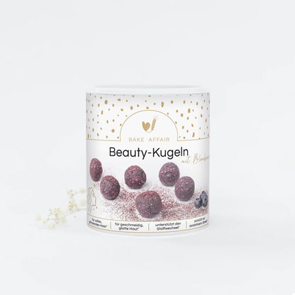 Runde, dunkelrote Beauty-Kugeln auf weißem Verpackungsbecher mit goldenen Punkten und Text 'Bake Affair Beauty-Kugeln'.