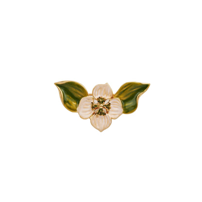 Goldfarbene Brosche in Form einer Blüte mit weißen Blütenblättern und zwei grünen Blättern, verziert mit kleinen grünen Punkten in der Mitte.