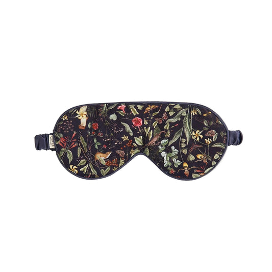 Schlafmaske aus Viskose mit kunstvollem botanischen Print: Wildblumen, Blätter, Beeren und Pflanzen in warmen Herbsttönen wie Rot, Orange, Gelb und Grün auf dunkelblauem bis schwarzem Untergrund; ergonomische Form mit weicher Polsterung und verstellbarem Satinband in Dunkelblau
