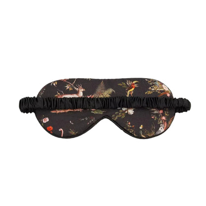 Schlafmaske mit künstlerischem Naturmotiv auf rotbraunem und schwarzem Untergrund: detaillierter Igel, Tagpfauenauge-Schmetterling, Wildblumen, Farnblätter und Beeren in warmen Herbstfarben wie Rostrot, Gelb, Grün und Orange, schwarzes Satinband mit Etikett, naturalistischer Vintage-Stil