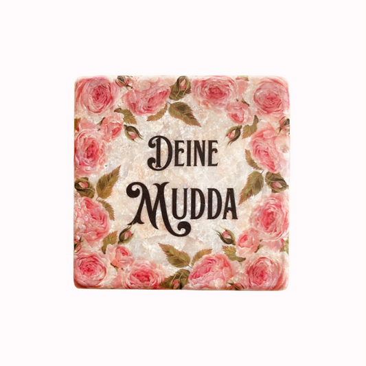 Quadratische Fliese mit Blumenmuster und dem Text 'DEINE MUDDA' in Großbuchstaben