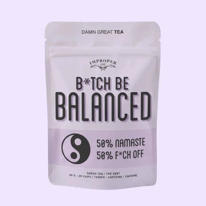 Teebeutelverpackung mit der Aufschrift 'B*TCH BE BALANCED', darunter ein Yin-Yang-Symbol und der Text '50% NAMASTE 50% F*CK OFF', oben 'DAMN GREAT TEA'.