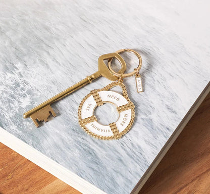 Goldener Schlüssel mit Schlüsselanhänger in Form eines Rettungsrings mit den Worten 'SEE NEED MORE VITAMINS'Goldener Schlüssel mit Schlüsselanhänger in Form eines Rettungsrings mit den Worten 'SEE NEED MORE VITAMINS'