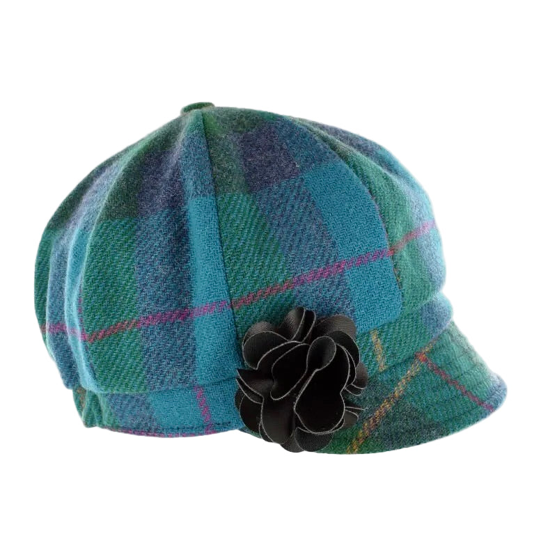 Karierte Mütze in Blau- und Grüntönen mit kleiner Stoffblume als Verzierung.