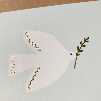 Weiße Taube mit Olivenzweig im Schnabel auf hellgrauem Hintergrund