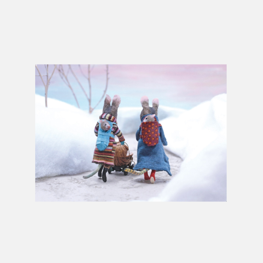 Zwei Mäudse in bunter Kleidung ziehen einen kleinen Wagen durch eine verschneite Landschaft bei Dämmerung.