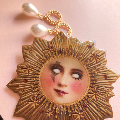 Goldene Sonne mit erhabenen Sternmustern und roten Schmucksteinen