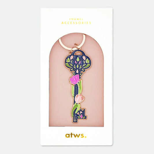 Schlüsselanhänger in Form eines Schlüssels mit floralem Muster und rosa Tulpen, verpackt auf einer weißen Karte mit der Aufschrift 'ENAMEL ACCESSORIES' und 'atws.'