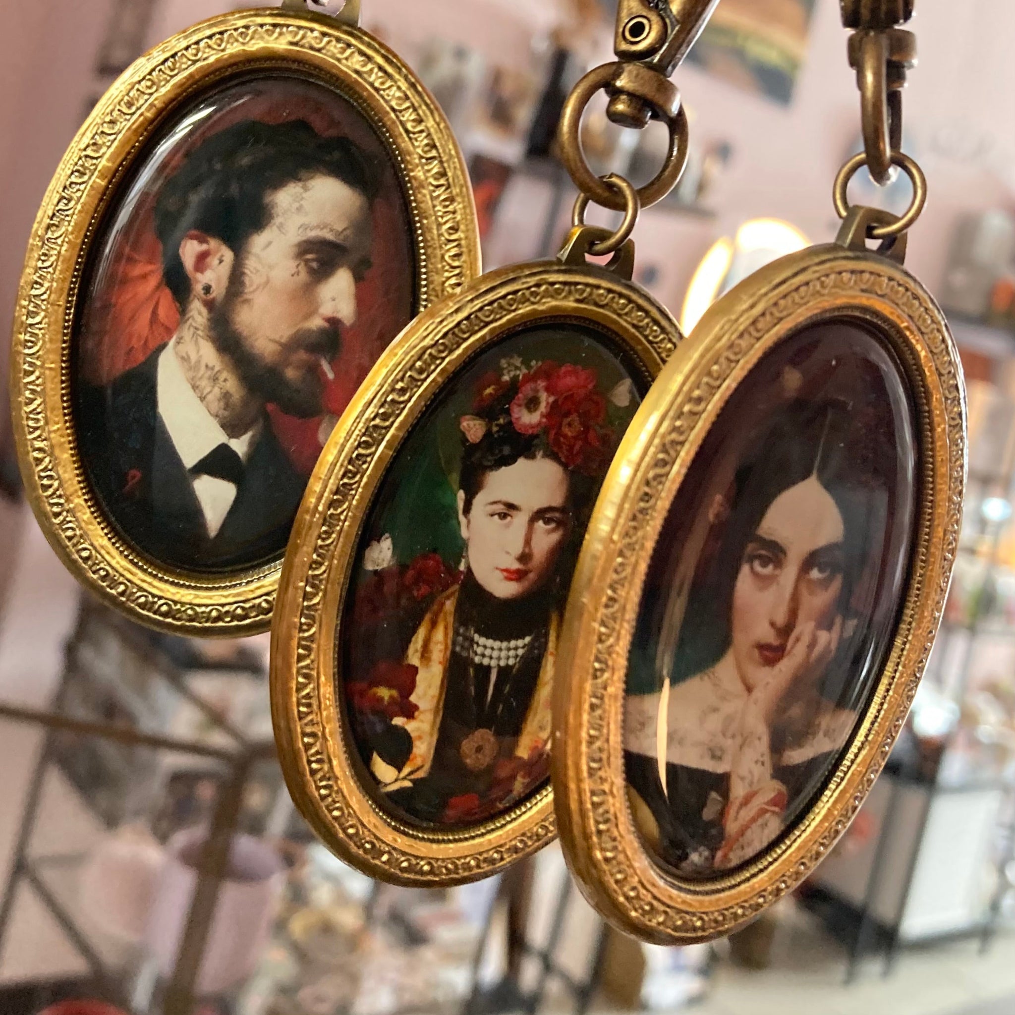 Drei ovale, goldgerahmte Anhänger mit historischen Porträtminiaturen, hängend an Metallringen