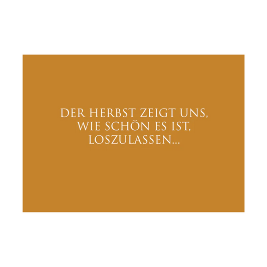 Dieses Bild zeigt eine  Postkarte mit deutschem Text auf senffarbenem Hintergrund. Die Karte enthält weißen Text in einer klaren, modernen Schriftart mit der folgender Botschaft: „DER HERBST ZEIGT UNS, WIE SCHÖN ES IST, LOSZULASSEN…“