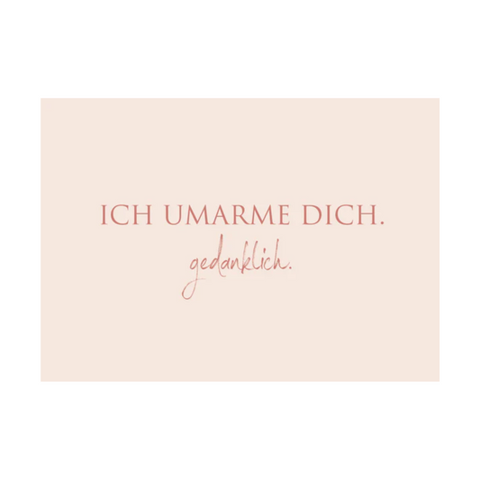 Dieses Bild zeigt eine Postkarte mit deutschem Text auf rosafarbenem Hintergrund. Der weinrote Text in klarer, moderner Schrift trägt die folgende Botschaft:
„ICH UMARME DICH.Gedanklich.