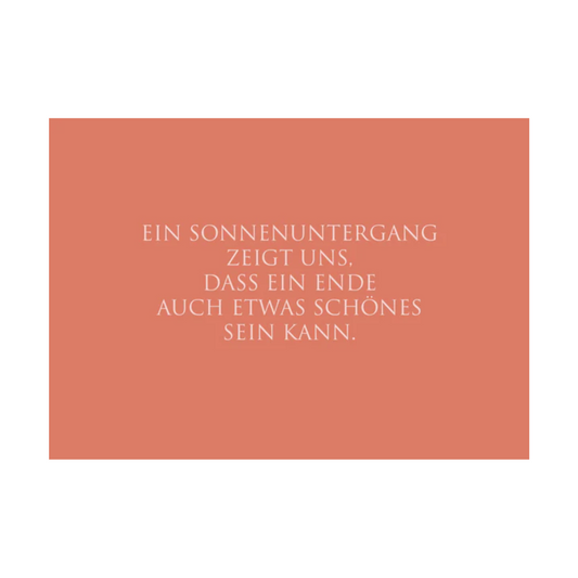 Die rotorangefarbene Postkarte verfügt über weißen Text in einer klaren, modernen Schriftart mit der folgenden  Botschaft: “EIN SONNENUNTERGANG ZEIGT UNS. DASS EIN ENDE AUCH ETWAS SCHÖNES SEIN KANN.”