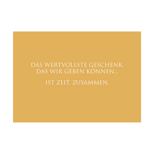 Dieses Bild zeigt eine inspirierende Grußkarte mit deutschem Text auf einem warmen gold-orangen Hintergrund. Die Karte enthält weißen Text in einer klaren, modernen Schriftart mit der folgenden motivierenden Botschaft in kurzen Sätzen: “DAS WERTVOLLSTE GESCHENK, DAS WIR GEBEN KÖNNEN…IST ZEIT. ZUSAMMEN.”