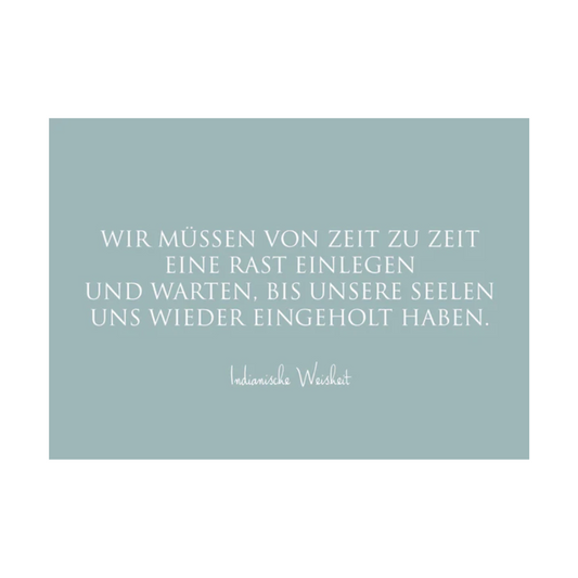 Dieses Bild zeigt eine Postkarte mit deutschem Text auf einem blaugrauem Hintergrund. Die Karte enthält weißen Text in einer klaren, modernen Schriftart mit der folgenden Botschaft in kurzen Sätzen: “WIR MÜSSEN VON ZEIT ZU ZEIT EINE RAST EINLEGEN UND WARTEN, BIS UNSERE SEELEN UNS WIEDER EINGEHOLT HABEN.”