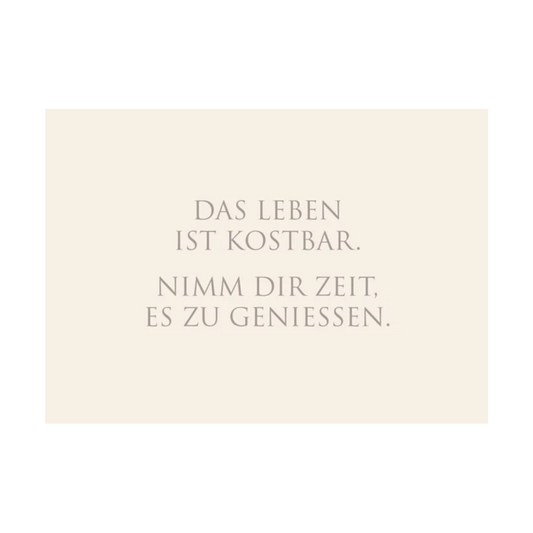 Dieses Bild zeigt eine  Postkarte mit deutschem Text auf cremefarbenem Hintergrund. Die Karte enthält grauen Text in einer klaren, modernen Schriftart mit der folgender Botschaft: „DAS LEBEN IST KOSTBAR. NIMM DIR ZEIT, ES ZU GENIESSEN.“