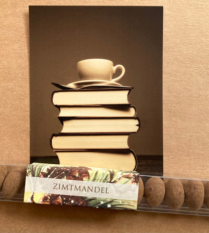 Lange, transparente Verpackung mit einer Reihe brauner Zimtmandeln und einem Etikett mit dem Schriftzug 'ZIMTMANDEL'.