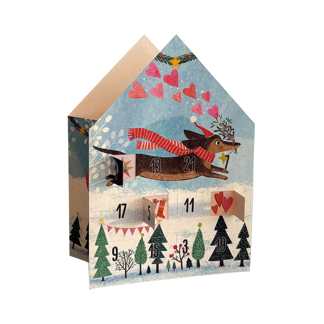  Blaues Adventskalender-Teelichthaus der Edition Gollong mit einem fliegenden Dackel, der eine Weihnachtsmütze und einen gestreiften Schal trägt.