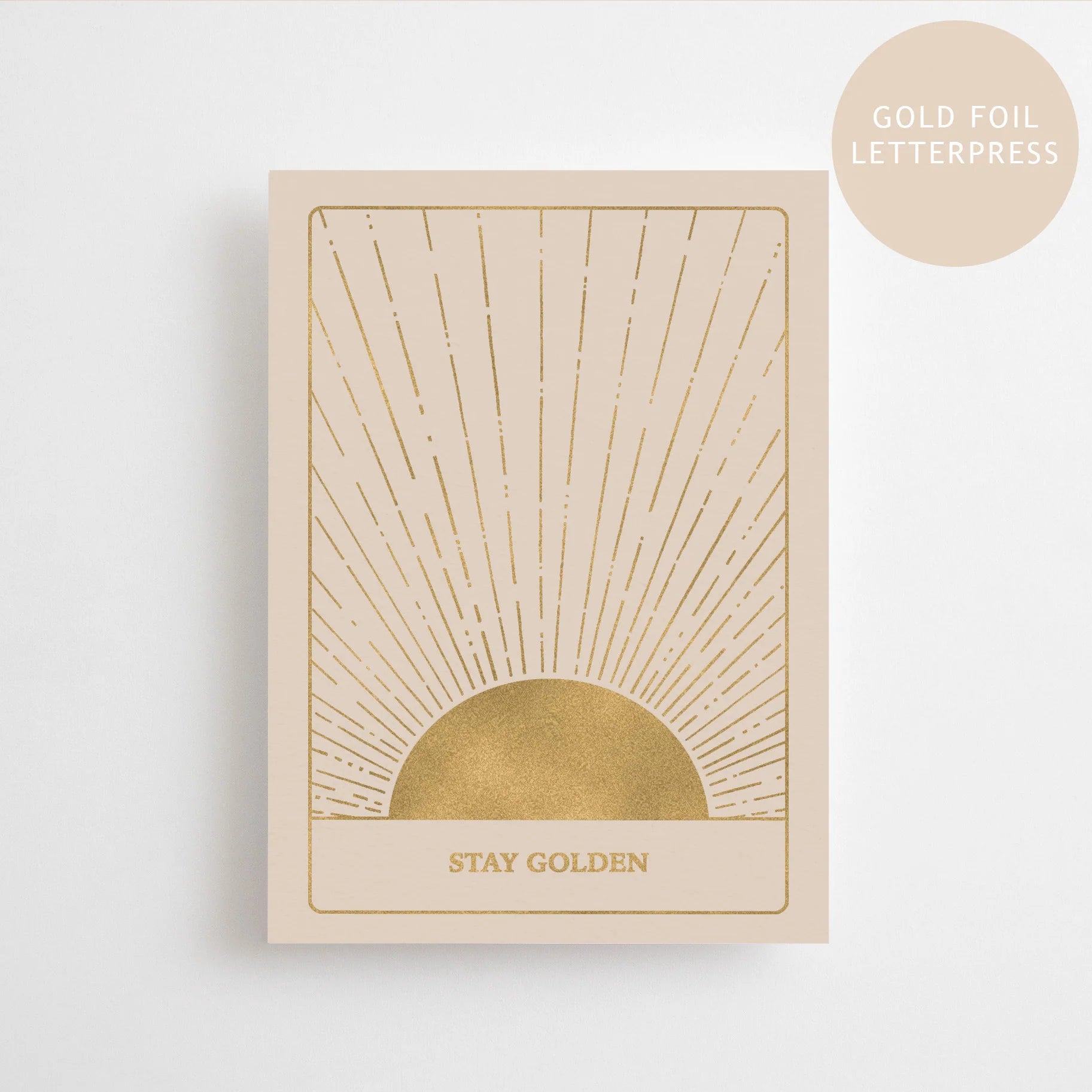 Elegante Letterpress-Postkarte von Anna Cosma mit einer geprägten, goldenen Sonne, feinen Strahlen und dem Schriftzug Stay Golden in Goldfolie.
