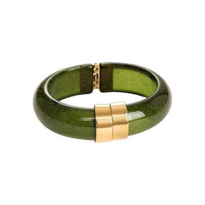 Eleganter smaragdgrüner Klapparmreif mit goldenem Verschluss und Glitzer-Effekt.