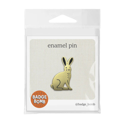Badge Bomb Emaille-Pin 'Hase' in Originalverpackung auf weißer Karte mit der Aufschrift 'enamel pin' und dem Logo der Marke.