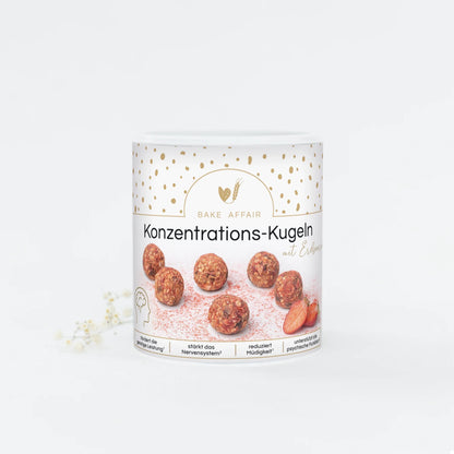 Runde Konzentrations-Kugeln in einer weißen Dose mit goldenen Punkten und der Aufschrift 'Bake Affair Konzentrations-Kugeln mit Erdbeere'.