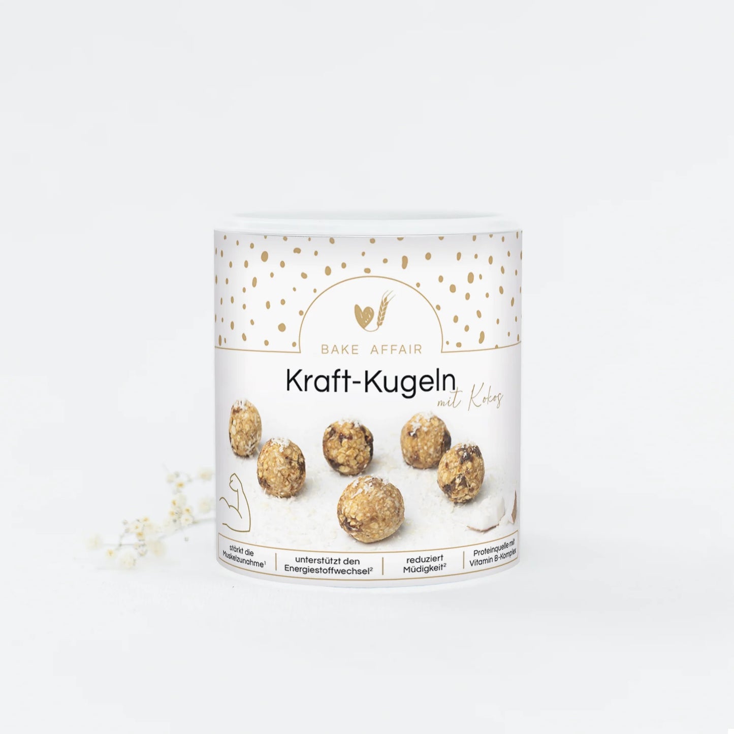 Runde Kraft-Kugeln mit Kokos auf weißem Verpackungsbecher von Bake Affair, umgeben von goldfarbenen Punkten.