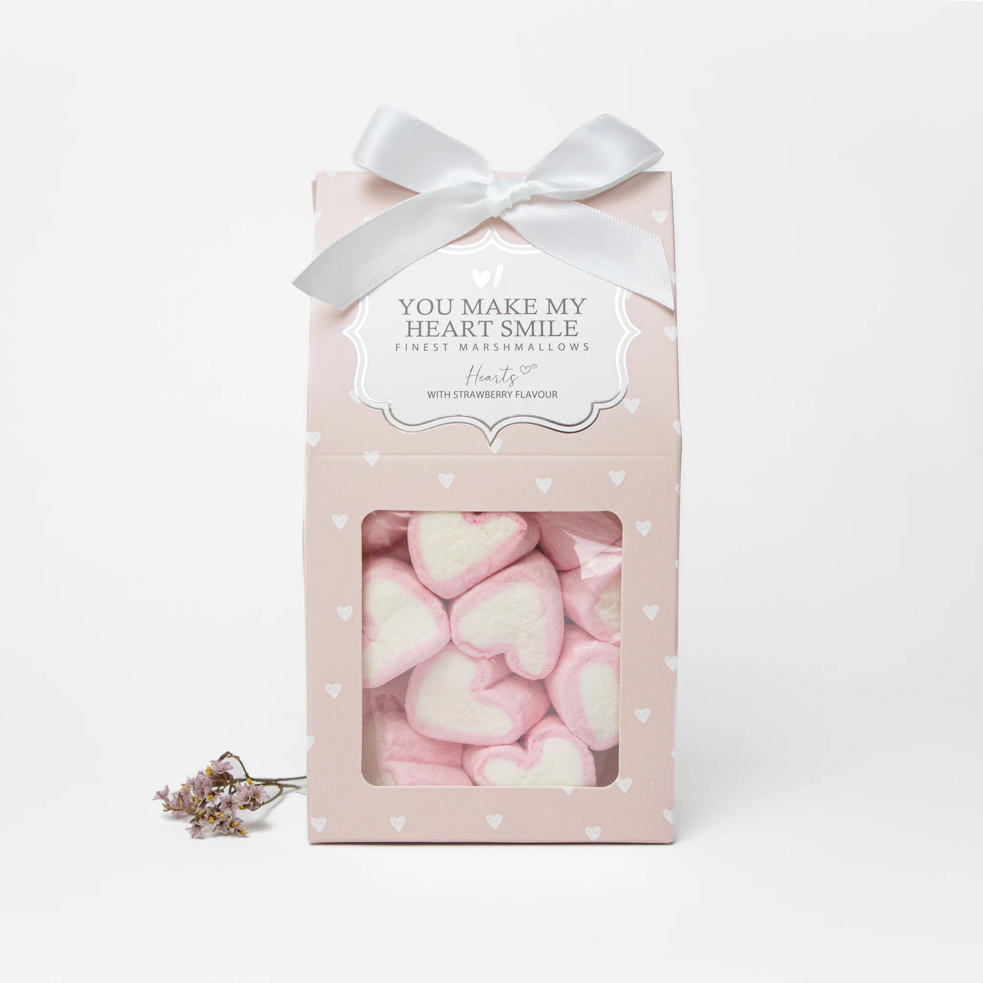 Rosa Geschenkbox mit Marshmallow-Herzen, weißer Schleife und Aufschrift „You make my heart smile“