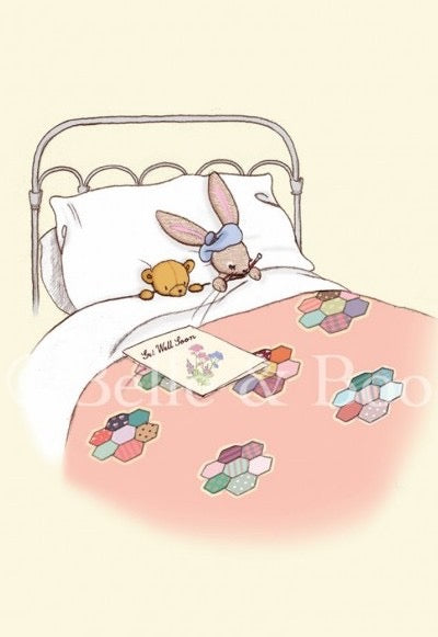 Ein Bett mit einem Metallrahmen, in dem ein Stoffhase mit blauer Mütze und ein Stoffbär unter einer Decke mit bunten sechseckigen Mustern liegen, auf der Decke liegt ein Buch mit dem Titel 'Get Well Soon'.